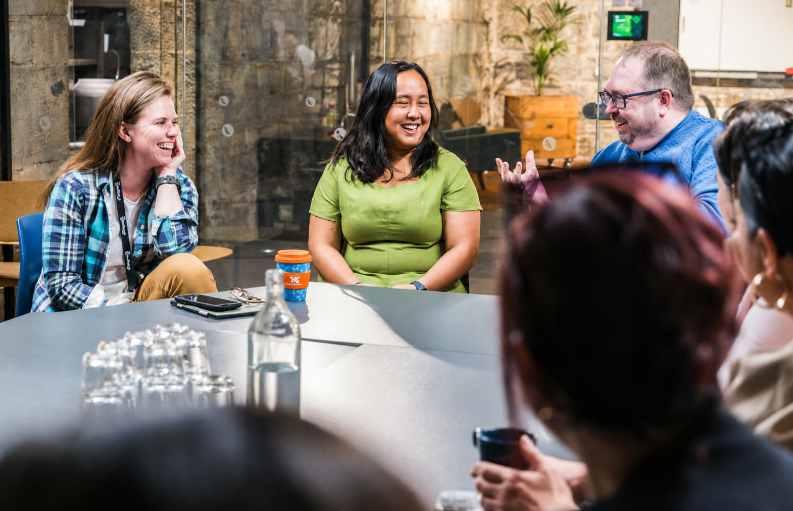 Founders around a table at a BUILTINCORK community meetup, laughing mid-conversation.
